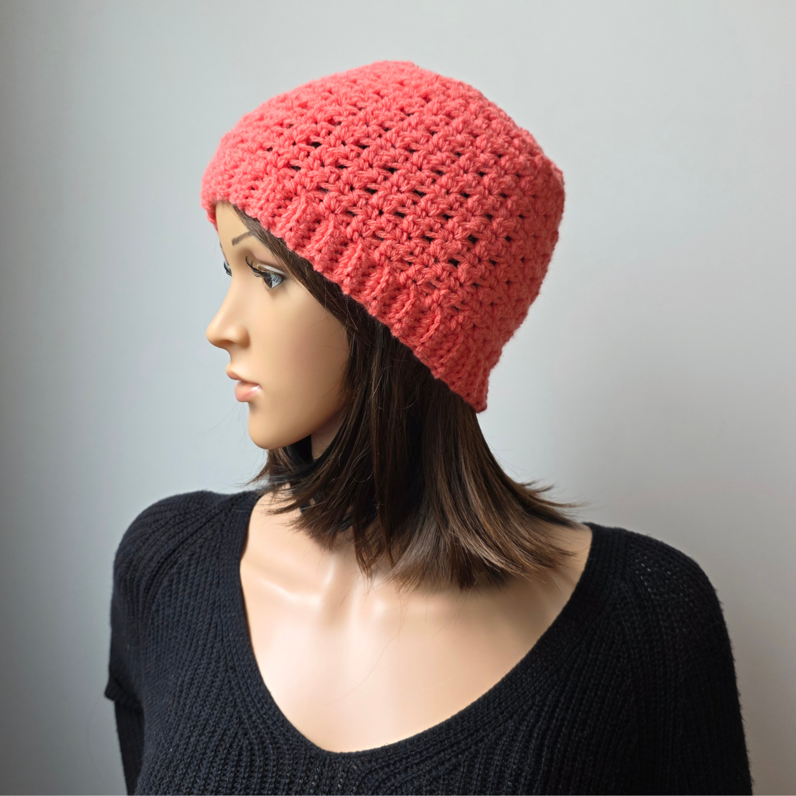 Siiew of the Coral Wander Hat on a mannequin head, showcasing the clean stitch pattern.