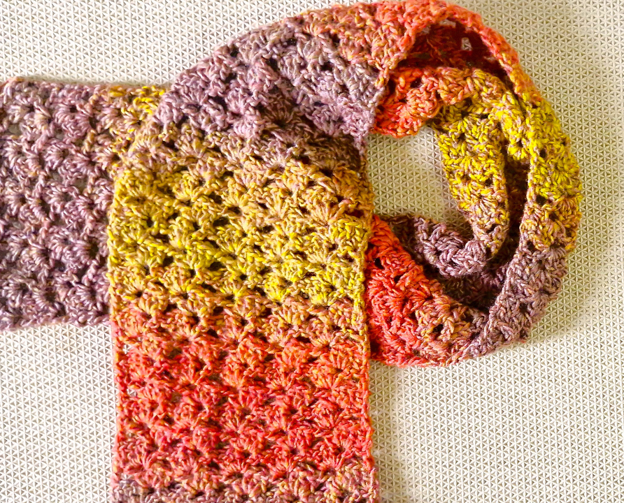 This cozy one-row repeat scarf works up quickly with worsted weight cake yarn and a 4 mm hook. The simple stitches make it easy to customize to any length or width.