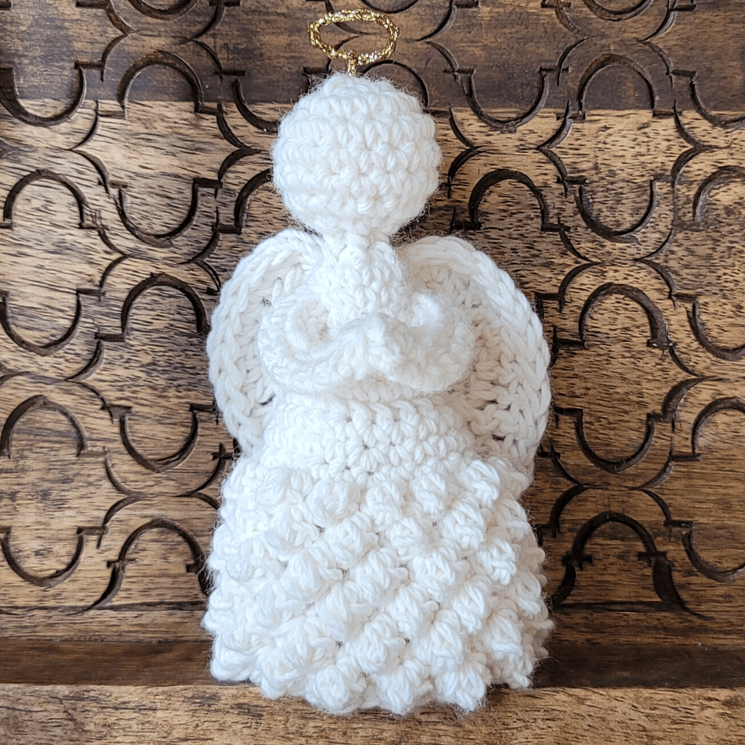 Create the Temperance Angel using medium-weight yarn and a 4 mm hook. This elegant self-standing crochet angel works up quickly and doesn’t require stiffening — perfect for holiday displays or thoughtful keepsakes.